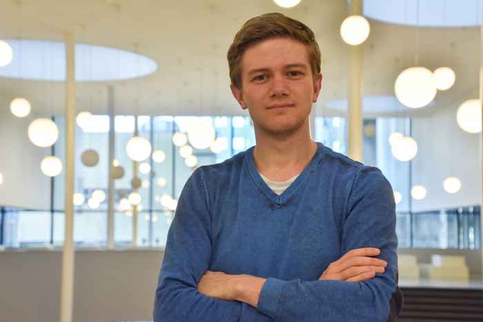 Student met blauwe trui en armen over elkaar